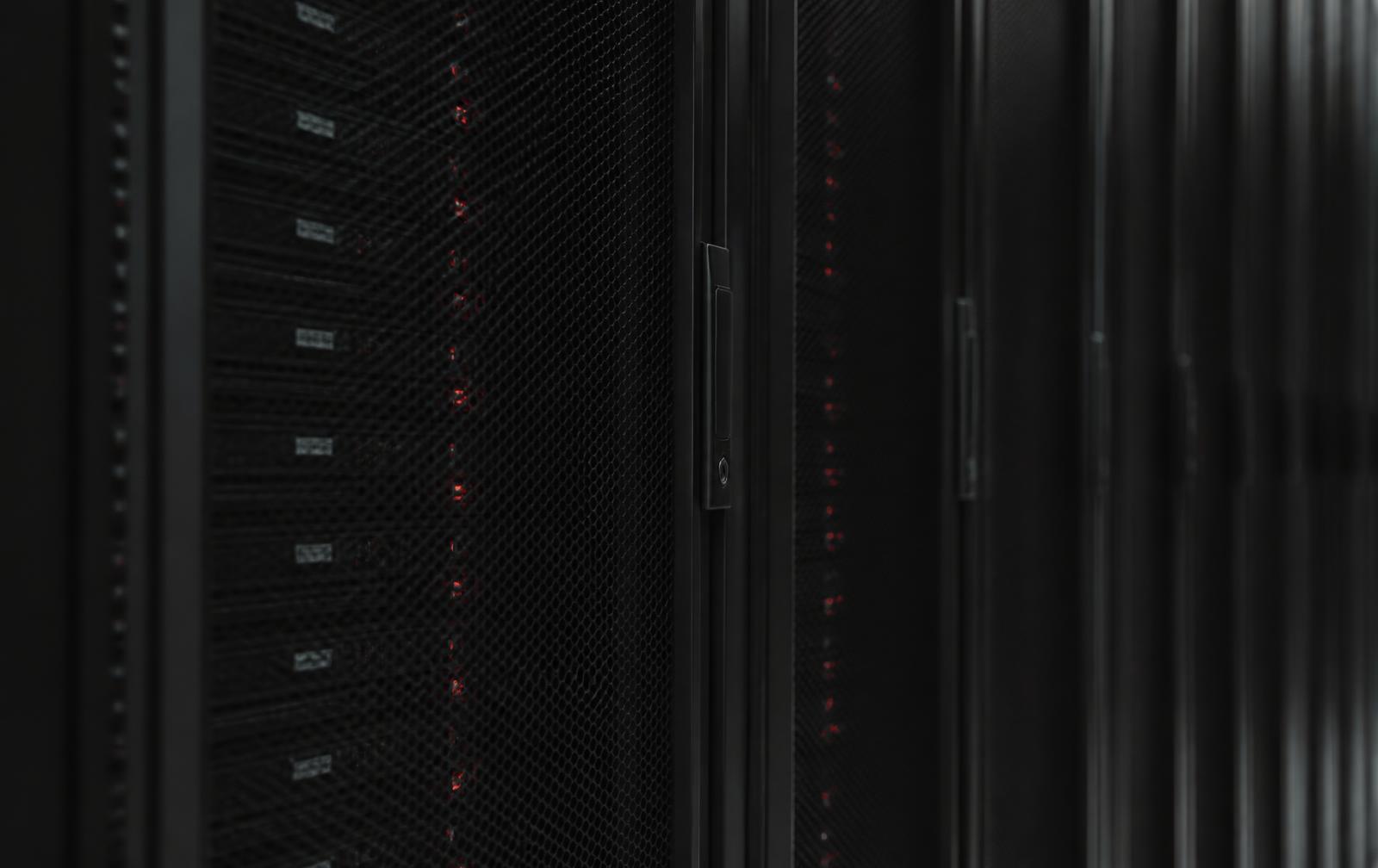 Server racks in a data centre aisle with small red status indicators